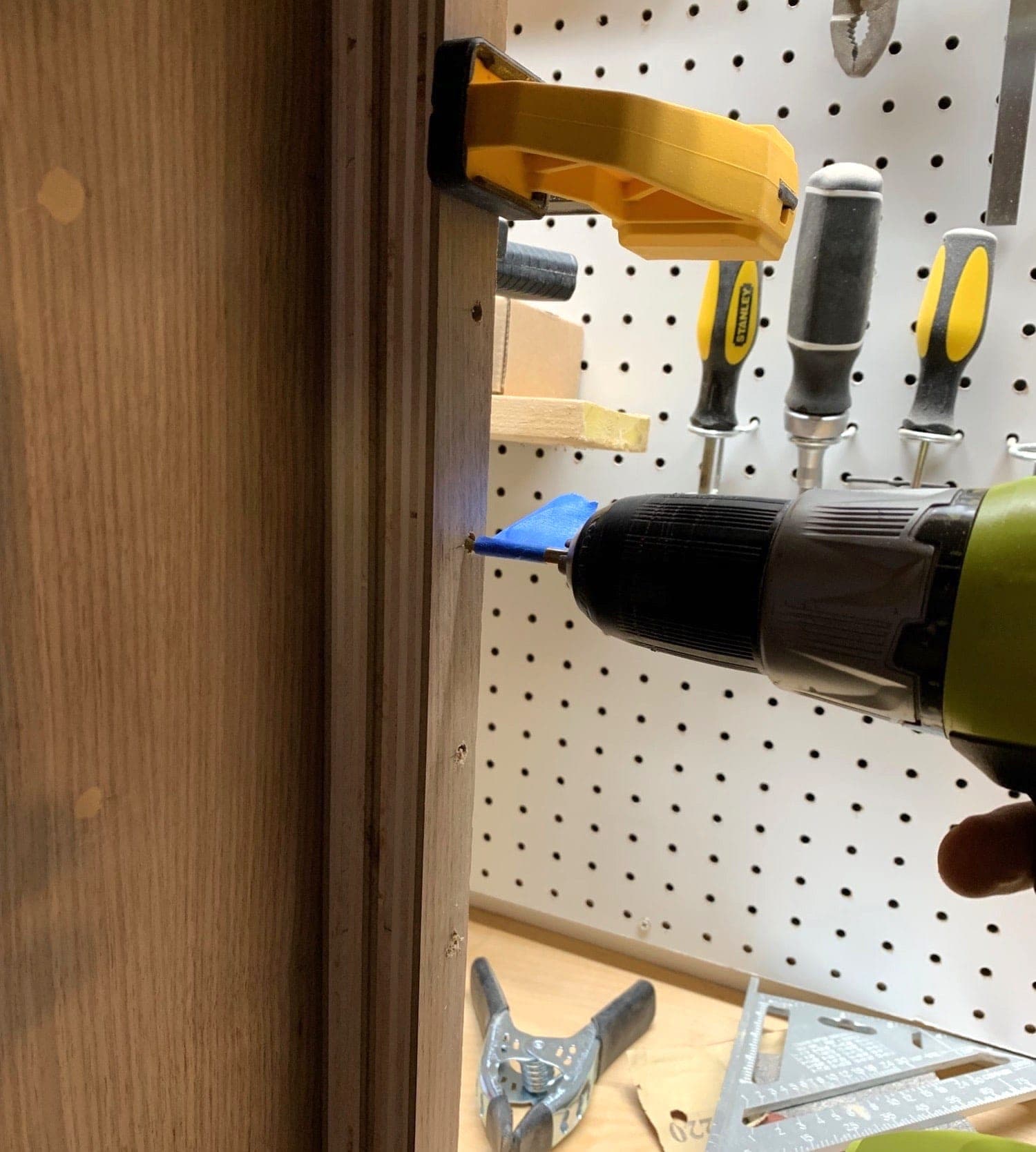 drilling peg holes using a piece of wood with pre-drilled holes as a jig