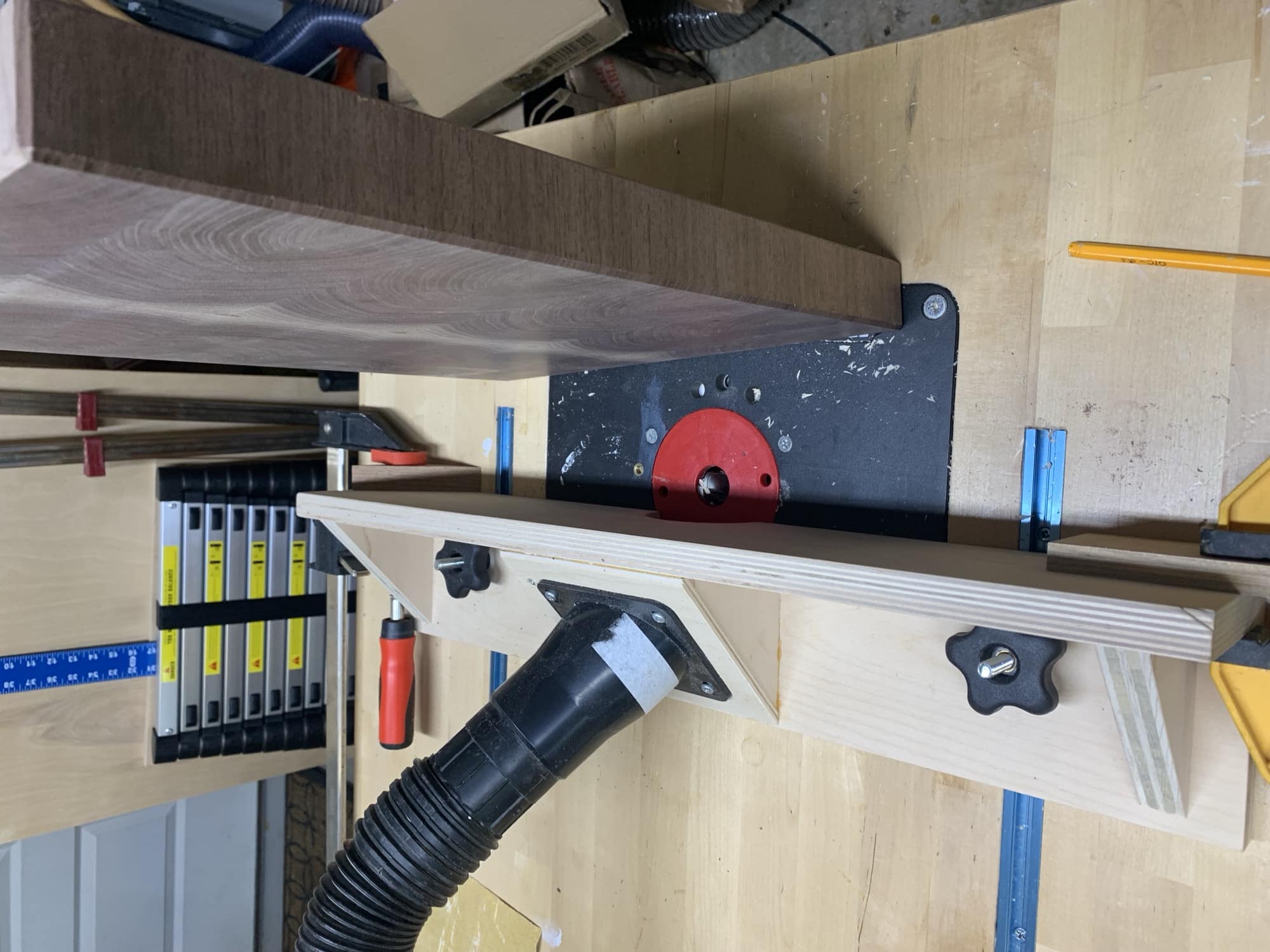 Router table set up with fence and cove bit. Board is standing up on edge